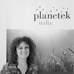 portrait of a woman in front of a sign saying "planetek italia"