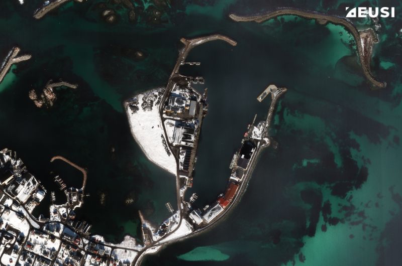 Very high resolution satellite image of a port, cargo ships are being loaded